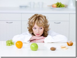 Woman choosing between fruits and cakes